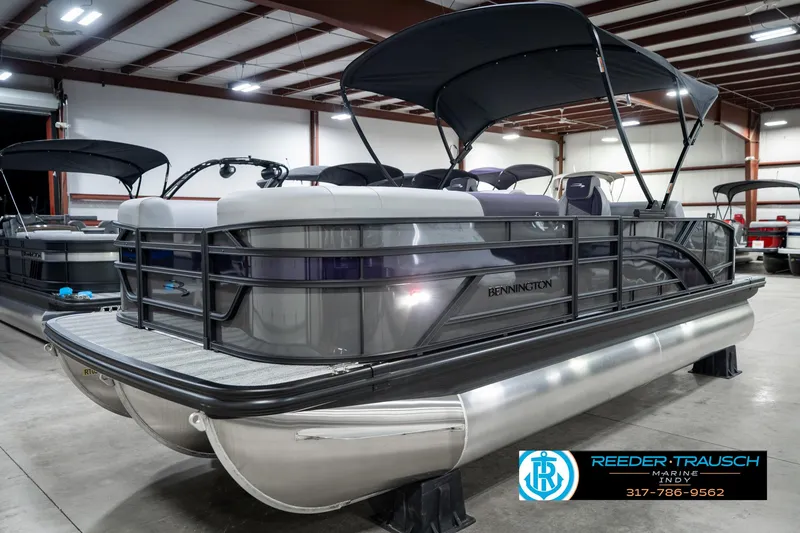 Slide: The Image of 2025 Bennington 21 SSB pontoon boat in showroom, featuring sleek design and black canopy. - 3