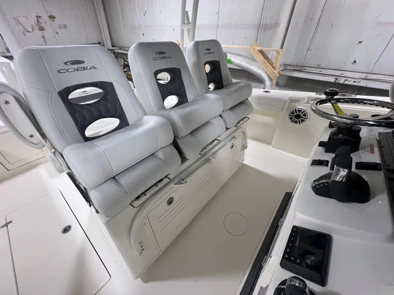 Slide: The Image of 2025 Cobia 350 Center Console boat interior with three cushioned seats and control panel. - 10
