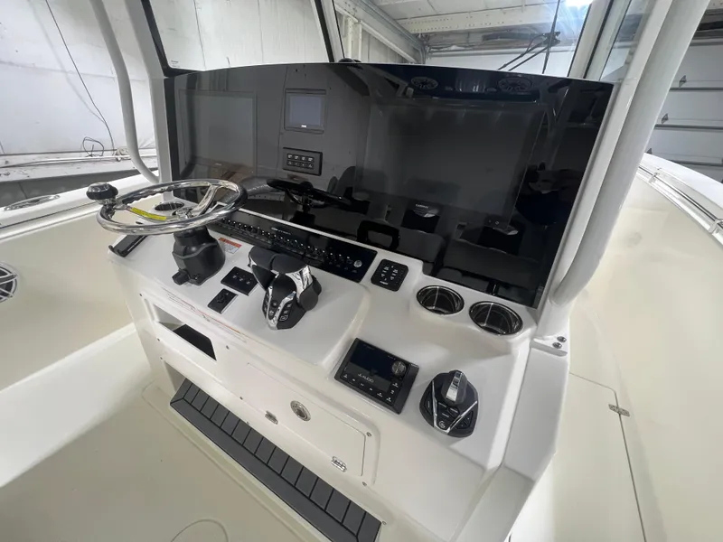 Slide: The Image of 2025 Cobia 350 Center Console boat dashboard with steering wheel and controls. - 11