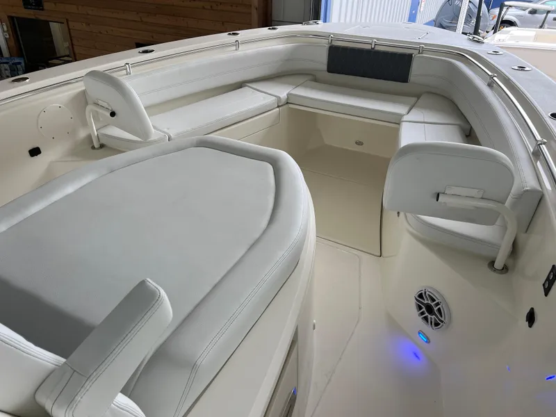 Slide: The Image of 2025 Cobia 350 Center Console boat interior with white seating and blue LED lights. - 16