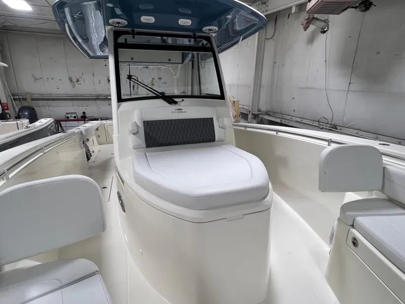 Slide: The Image of 2025 Cobia 350 Center Console boat interior with seating and helm in a showroom. - 19