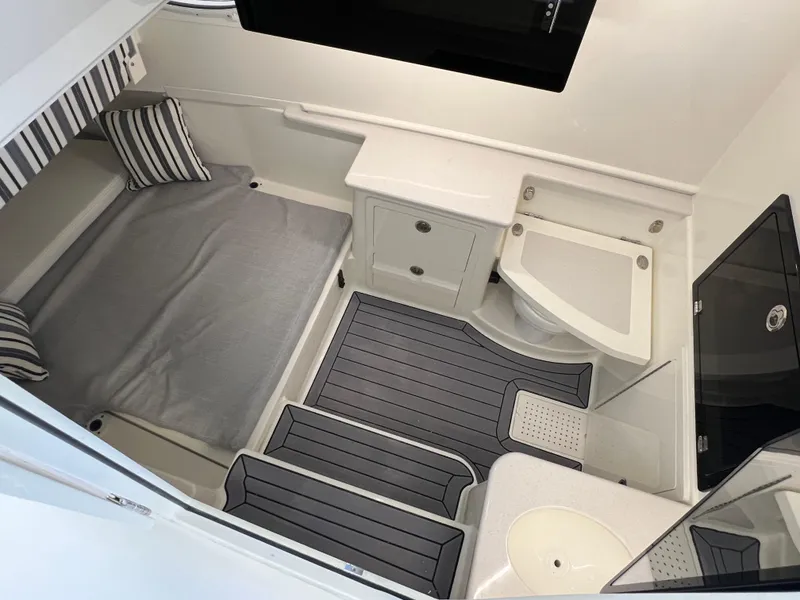 Slide: The Image of 2025 Cobia 350 Center Console cabin interior with bed, seating, and storage. - 22