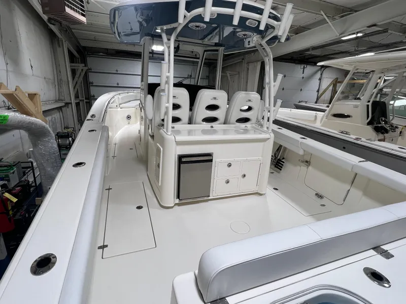 Slide: The Image of 2025 Cobia 350 Center Console boat interior with seating and storage in a showroom. - 3