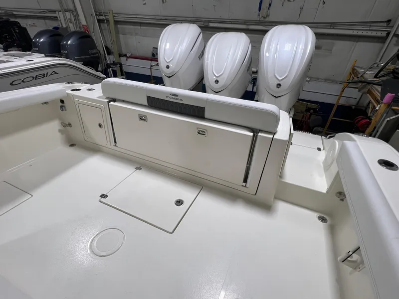Slide: The Image of 2025 Cobia 350 Center Console boat with triple outboard engines in a showroom. - 4