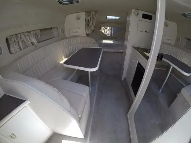 Slide: The Image of Interior of a 1998 Rinker Fiesta Vee 280EC boat with seating and kitchenette. - 10