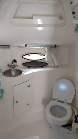 Slide: The Image of 1998 Rinker Fiesta Vee 280EC boat bathroom with sink, toilet, and storage cabinet. - 13