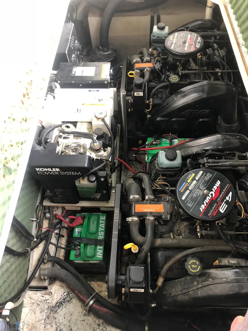 Slide: The Image of Engine compartment of a 1998 Rinker Fiesta Vee 280EC boat, featuring dual engines and battery system. - 15