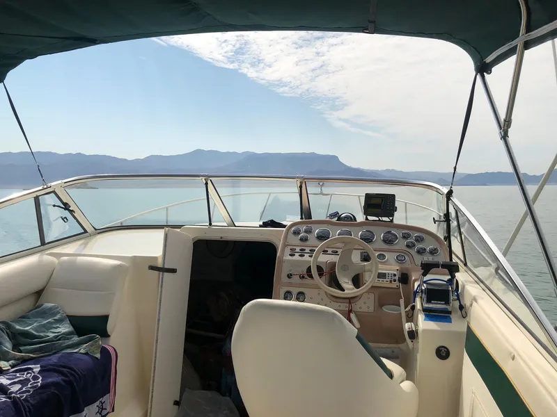 Slide: The Image of 1998 Rinker Fiesta Vee 280EC boat interior with steering wheel, dashboard, and scenic water view. - 16