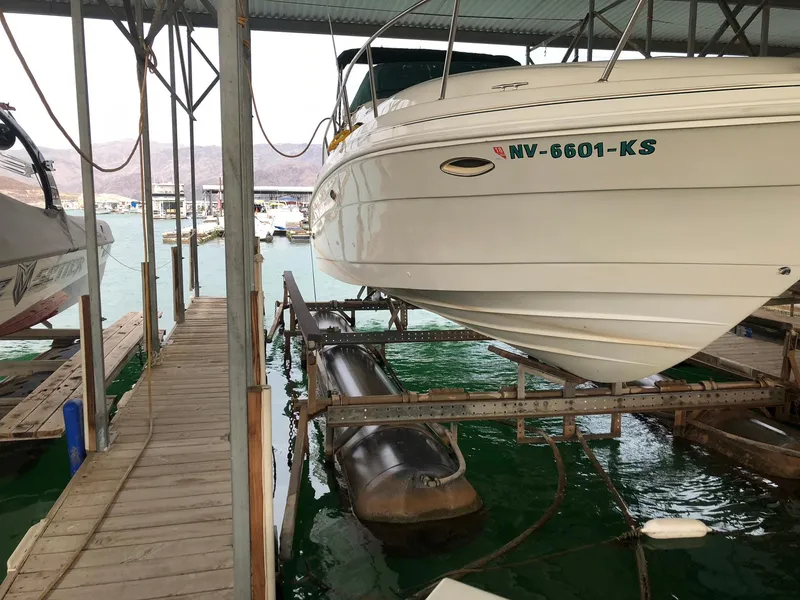 Slide: The Image of 1998 Rinker Fiesta Vee 280EC boat docked in a marina with green water. - 4