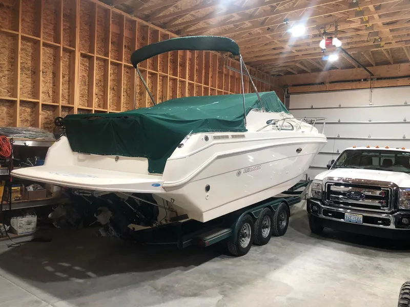 Slide: The Image of 1998 Rinker Fiesta Vee 280EC boat in garage, covered, next to a truck. - 7