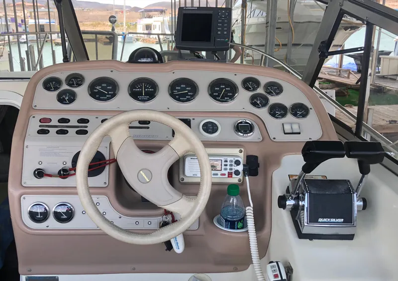 Slide: The Image of 1998 Rinker Fiesta Vee 280EC boat dashboard with steering wheel and control panel. - 9
