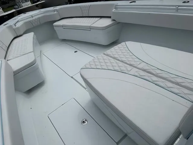 Slide: The Image of 2024 Contender 39 ST boat interior with white cushioned seating and storage compartments. - 14
