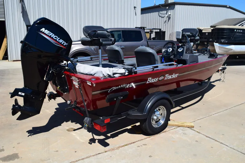 Slide: The Image of 2021 Tracker Bass Tracker Classic XL boat with Mercury engine, parked outdoors. - 3