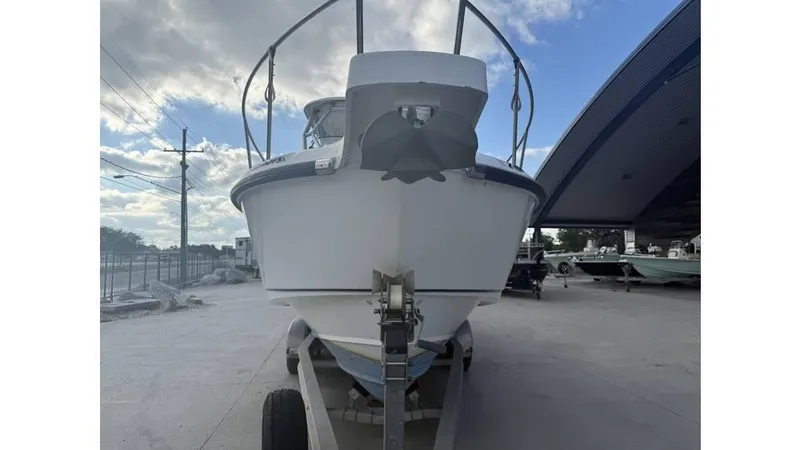 Slide: The Image of 2006 Boston Whaler 285 Conquest boat on trailer, under cloudy sky. - 9