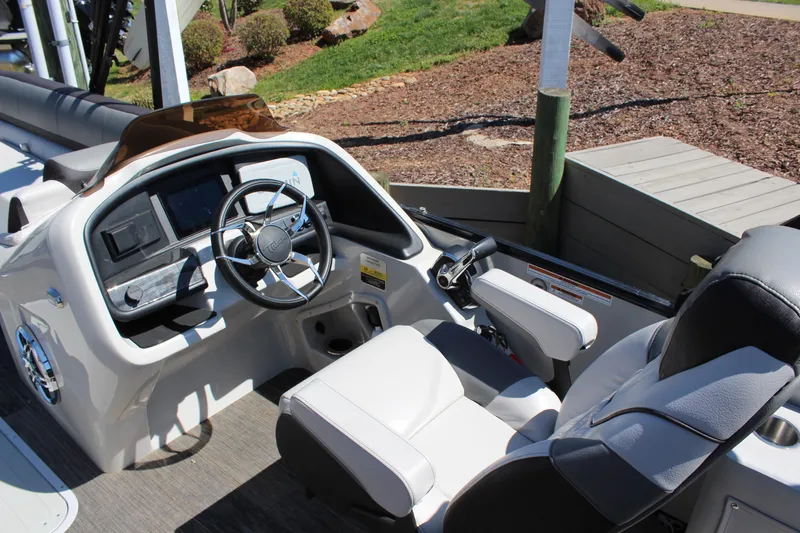 Slide: The Image of 2023 Tahoe Pontoon Cascade Platinum Versatile Rear Bench 25' helm with modern controls and seating. - 11