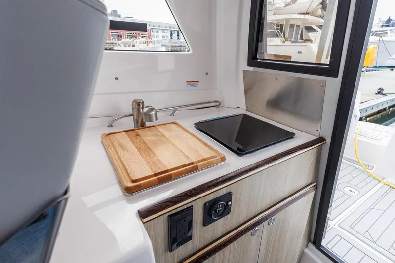Slide: The Image of Compact kitchen area in 2026 Solara 250-C boat with sink and cooktop. - 12