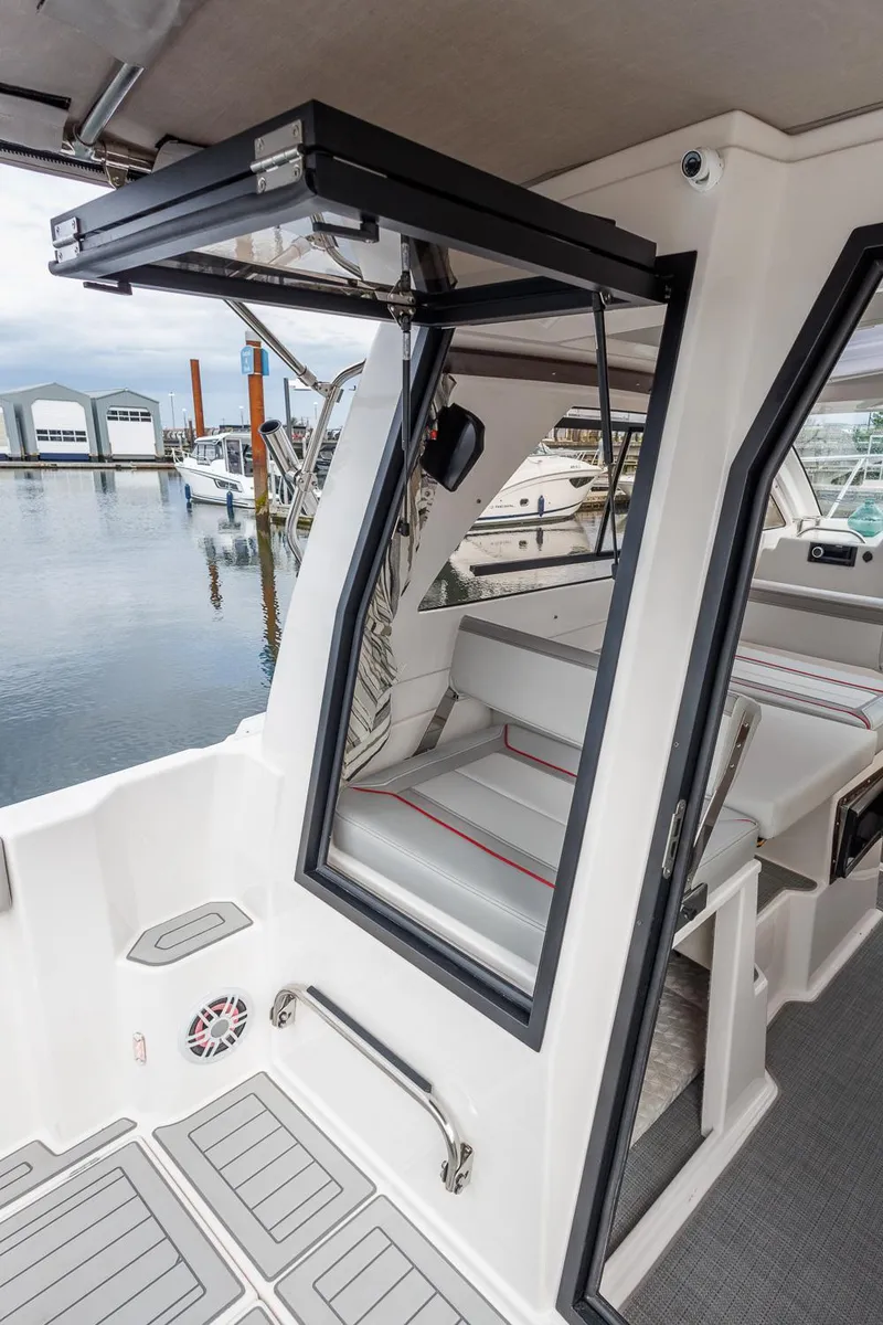 Slide: The Image of 2026 Solara 250-C boat interior with open door, dockside view. - 24