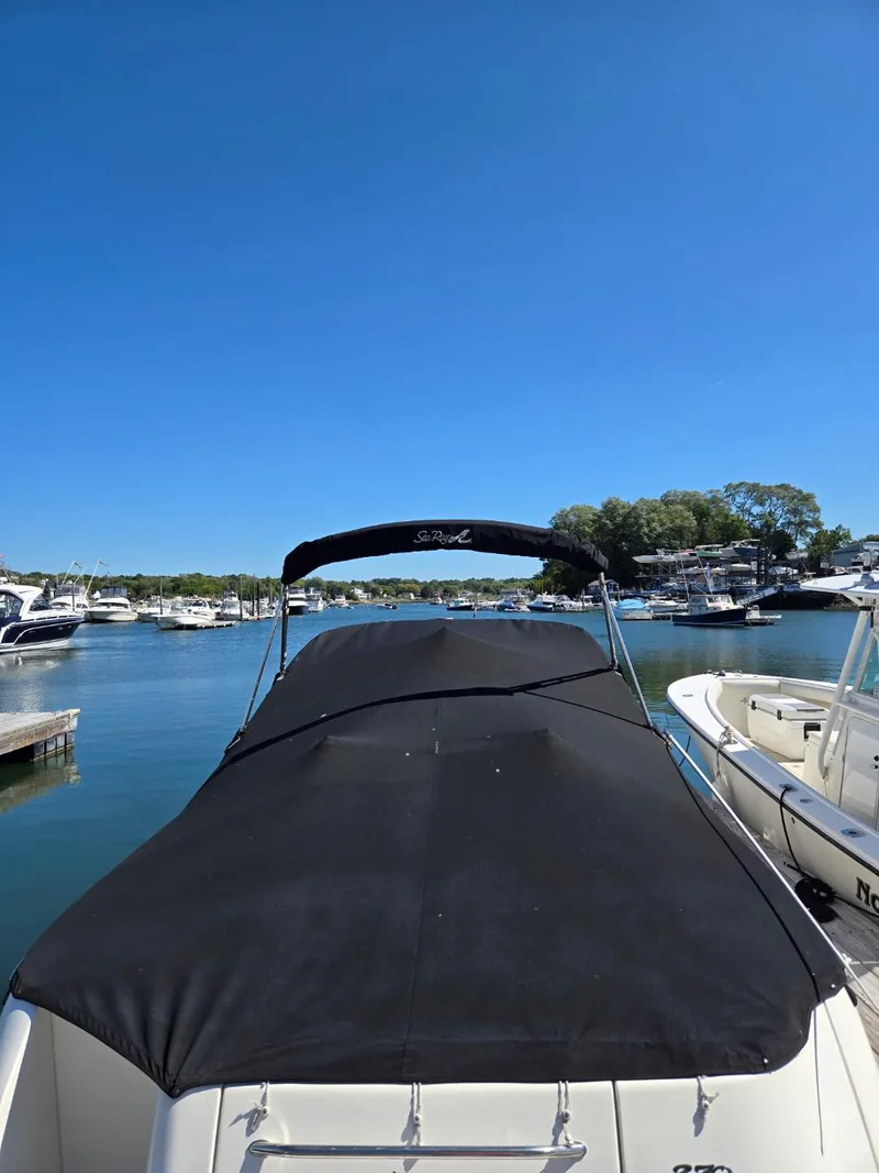 Slide: The Image of 2006 Sea Ray 270 Amberjack boat docked in a marina under clear blue skies. - 4