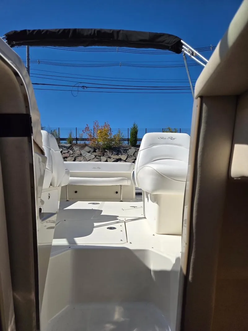 Slide: The Image of 2006 Sea Ray 270 Amberjack boat interior with white seating and blue sky background. - 7