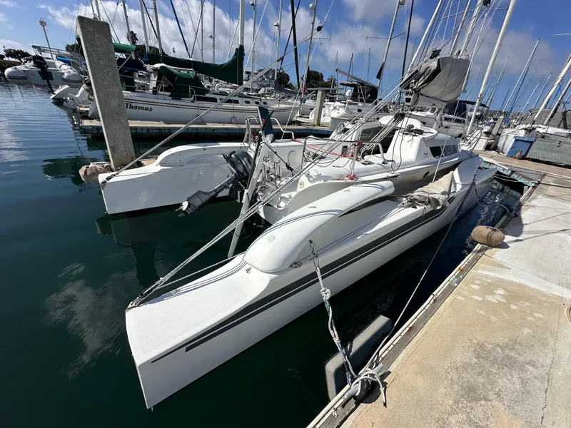 Slide: The Image of 2021 Dragonfly 25 Touring trimaran docked at a marina under a clear blue sky. - 20