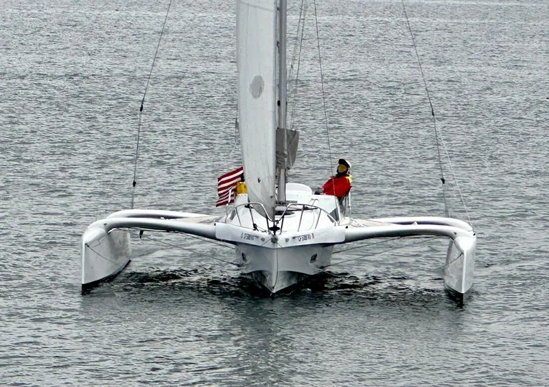 Slide: The Image of 2021 Dragonfly 25 Touring trimaran sailing on calm waters with an American flag. - 4