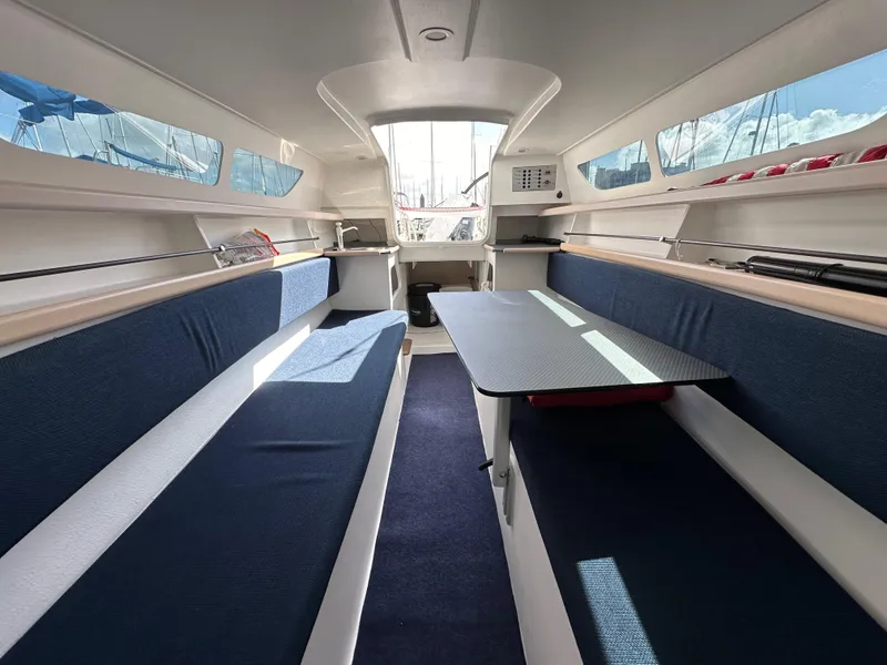 Slide: The Image of Interior of 2021 Dragonfly 25 Touring sailboat with blue seating and table. - 43