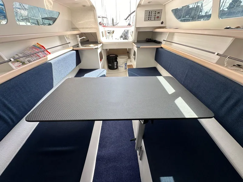 Slide: The Image of Interior of 2021 Dragonfly 25 Touring sailboat with blue seating and central table. - 44