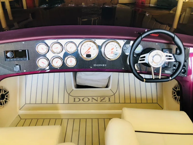 Slide: The Image of 2022 Donzi Classic boat dashboard with gauges and steering wheel. - 5