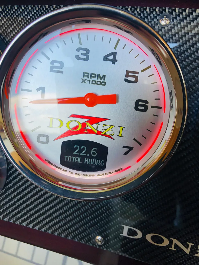 Slide: The Image of 2022 Donzi Classic tachometer displaying RPM and total hours on carbon fiber panel. - 7