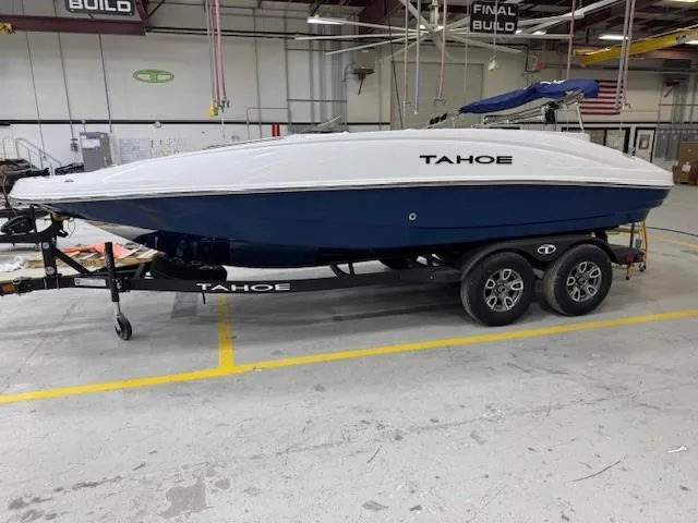 Slide: The Image of 2024 Tahoe 1950 boat on trailer in warehouse setting. - 0