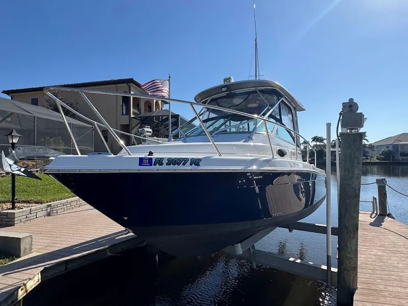 Slide: The Image of 2012 Robalo R265 Walkaround boat docked in sunny waterfront setting. - 0