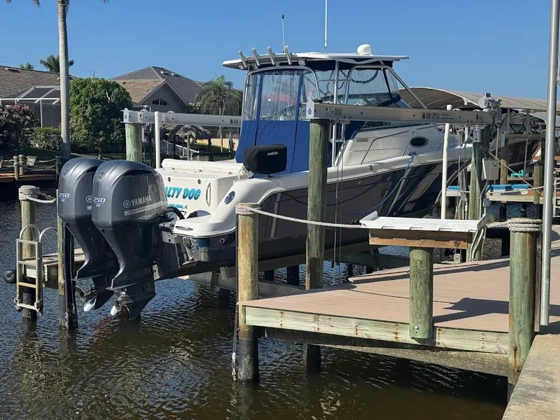 Slide: The Image of 2012 Robalo R265 Walkaround boat docked with dual Yamaha engines. - 7