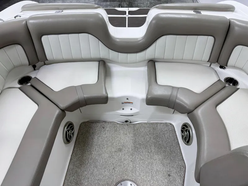 Slide: The Image of 2009 Yamaha Boats 232 Limited S interior with gray and white seating, carpeted floor, and cup holders. - 11
