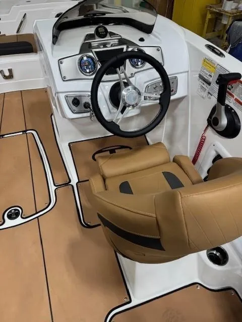 Slide: The Image of 2024 Tahoe 1950 boat interior with tan seating and modern dashboard controls. - 10