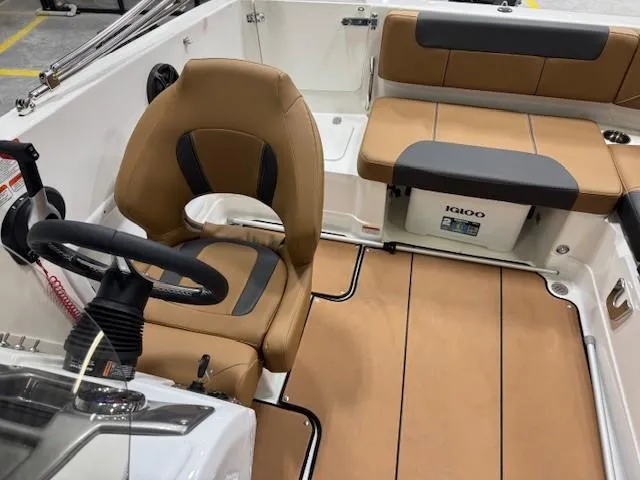 Slide: The Image of 2024 Tahoe 1950 boat interior with tan seating and steering wheel. - 11