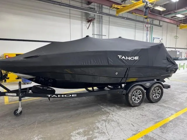 Slide: The Image of 2024 Tahoe 1950 boat covered on trailer in industrial setting. - 6