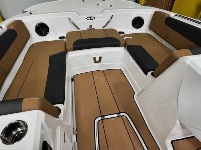 Slide: The Image of 2024 Tahoe 1950 boat interior with brown and black seating, cup holders, and speakers. - 9