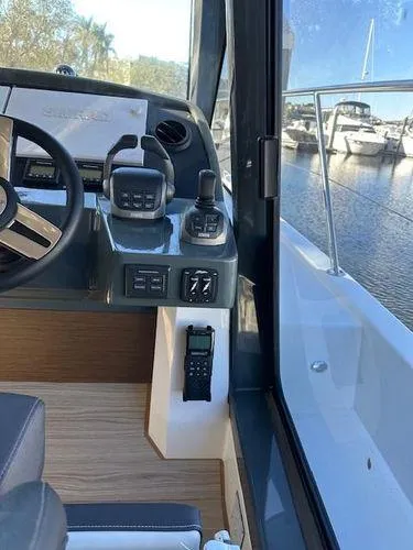 Slide: The Image of 2023 Bavaria R40 Coupe cockpit with modern controls, docked at a marina. - 20