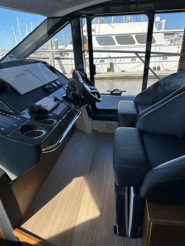 Slide: The Image of 2023 Bavaria R40 Coupe interior with modern dashboard and comfortable seating, docked at marina. - 24