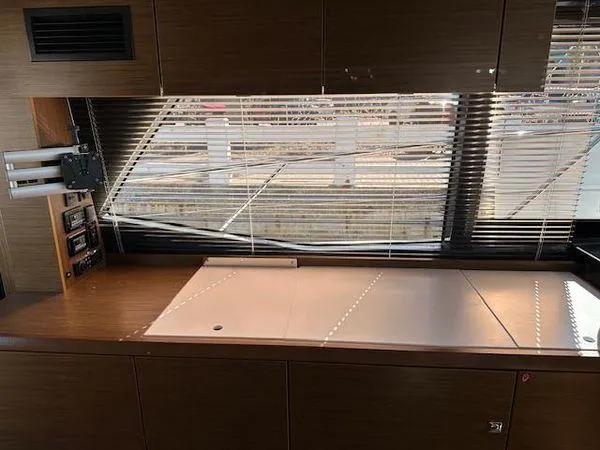 Slide: The Image of Interior of 2023 Bavaria R40 Coupe yacht with sleek wooden cabinetry and large window blinds. - 30