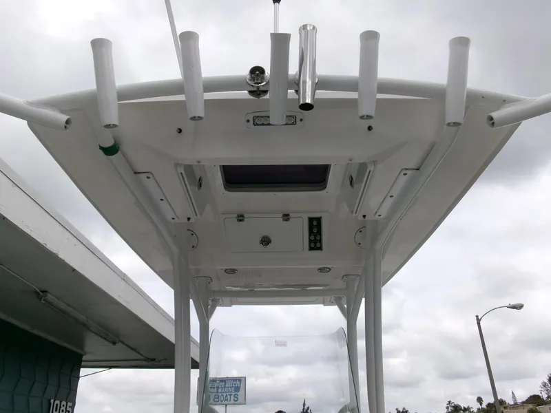 Slide: The Image of 2020 Sea Fox 248 Commander boat's T-top with rod holders and electronics, under cloudy sky. - 20