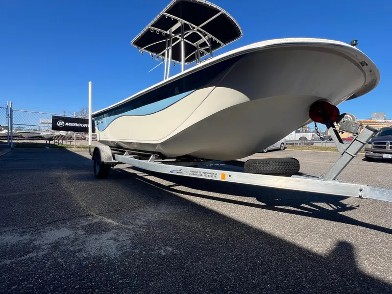 Slide: The Image of 2016 Carolina Skiff 198 DLV boat on trailer, parked outdoors under clear blue sky. - 11