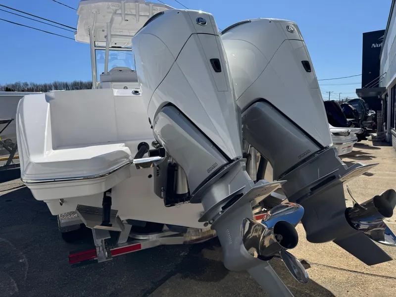 Slide: The Image of 2025 Aquasport 28AS Center Console with dual outboard engines, docked on a sunny day. - 4