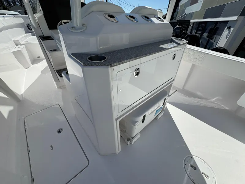 Slide: The Image of 2025 Aquasport 28AS Center Console boat interior with storage and control panel. - 9