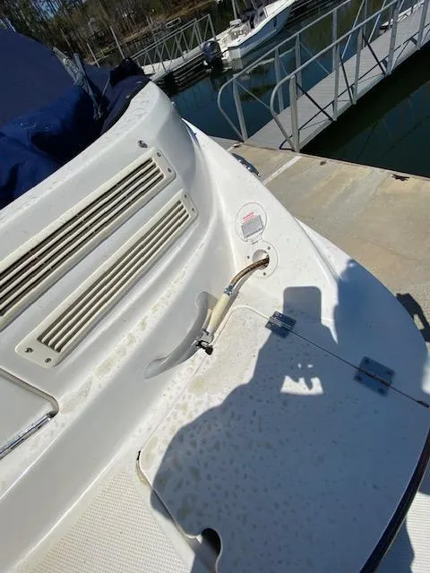 Slide: The Image of 2005 Bayliner 249 SD boat docked, showing deck details and marina background. - 11