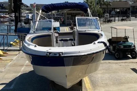 Slide: The Image of 2005 Bayliner 249 SD boat docked at a marina, front view. - 16