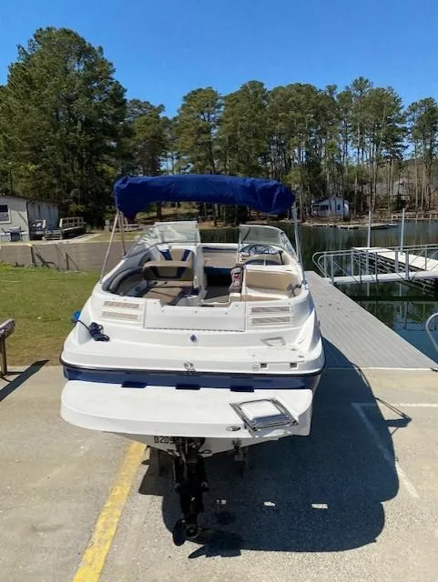 Slide: The Image of 2005 Bayliner 249 SD boat docked at a marina with trees in the background. - 3