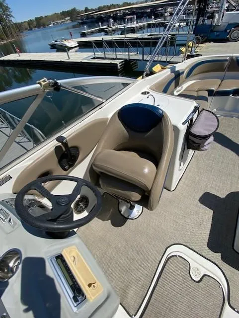 Slide: The Image of 2005 Bayliner 249 SD boat interior with steering wheel and seating, docked at marina. - 5
