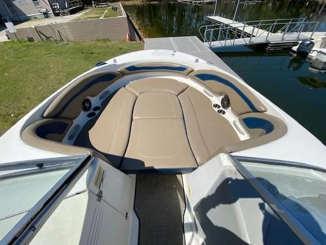 Slide: The Image of 2005 Bayliner 249 SD boat interior with tan seating and cup holders, docked by the water. - 8