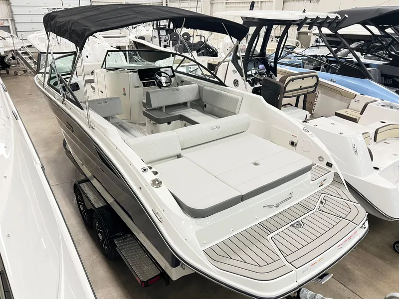 Slide: The Image of 2025 Sea Ray SDX 250 boat with sleek design and spacious seating in showroom. - 2